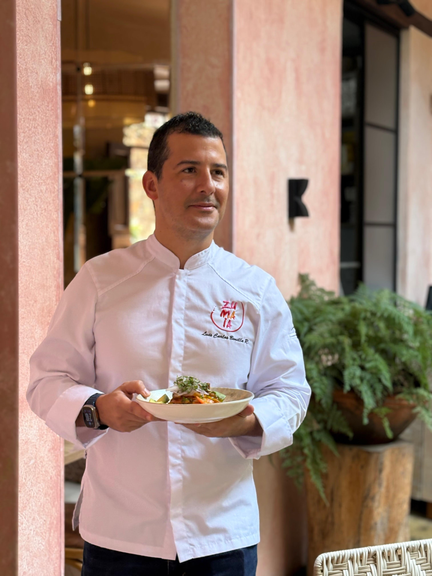 Luis Carlos Bonilla, chef de ZUMAIA, sosteniendo un plato emplatado del menú a varios tiempos